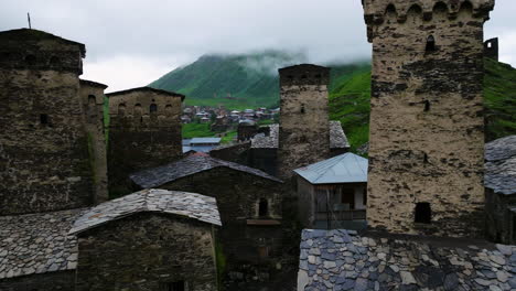 The-Old-Alpine-Village-Ushguli-On-A-Rainy-Day,-Caucasus-Mountains,-Svaneti-Region,-Georgia---aerial-pullback