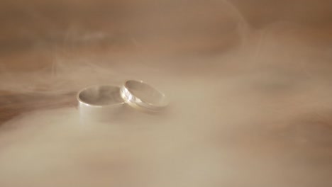 Wedding-rings-on-wood-counter-in-smoke-in-super-slow-motion---60-seconds
