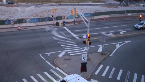 Moving-aerial-shot-of-intersection-with-a-pacing-man-in-work-wear-on-his-phone