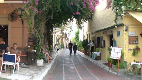 Tourists-walking-in-narrow-street-in-the-traditional-Plaka-Town-near-Acropolis-in-Athens,-Greece