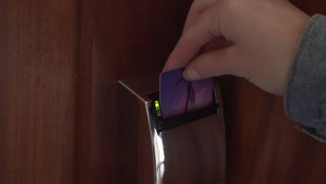 Close-up-of-hotel-key-card-unlocking-room-door-by-putting-in-key-card