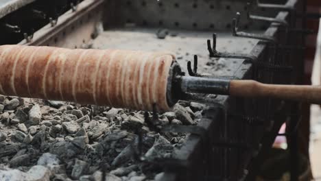 Herstellung-Eines-Ungarischen-Kaminkuchens-über-Der-Glühenden-Glut-Durch-Drehen-Durch-Menschenhand