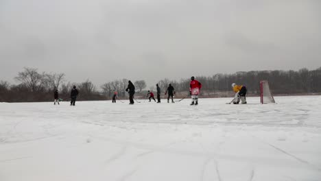 A-wide-angle-hyperlapse-from-the-field-corner-of-adults-and-children-pond-hockey-during-snowy-conditions