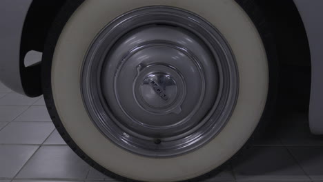 Close-up-on-original-elegant-styled-white-wall-tyre---shiny-classic-wheel-hub-on-British-Jaguar-model-vehicle