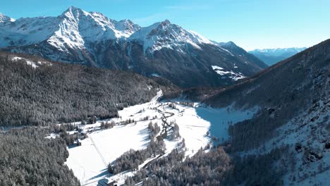 Luftaufnahme-Einer-Schneebedeckten-Berglandschaft-Mit-Wäldern-Und-Flüssen-An-Einem-Sonnigen-Wintertag-In-Alp-Grüm,-Schweiz