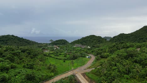 Toma-Aérea-De-Drones-De-La-Carretera-En-La-Exuberante-Selva-Tropical-En-La-Ciudad-De-Bato,-Catanduanes,-Filipinas
