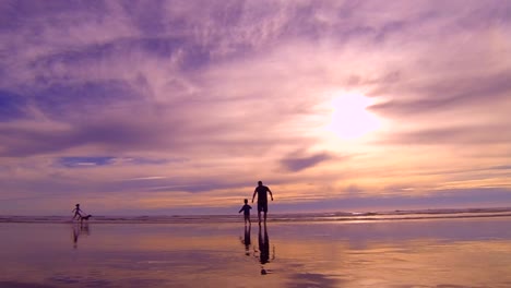 A-father-and-son-running-out-to-the-ocean-during-sunset-at-Cannon-Beach