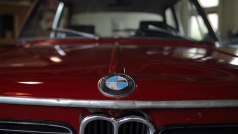Pull-away-dolly-shot-of-a-red-antique-BMW-logo
