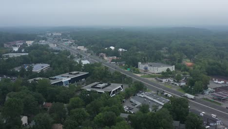 aerial-footage-of-suburban-highway-with-office-buildings-and-traffic-in-the-fog