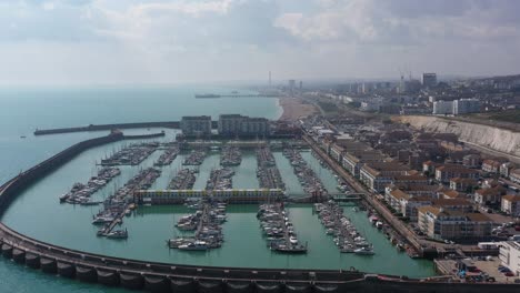 Aerial-pan-up-reveal-from-Brighton-Marina-to-the-Town,-Brighton-beach,-Pier-and-I360-attraction