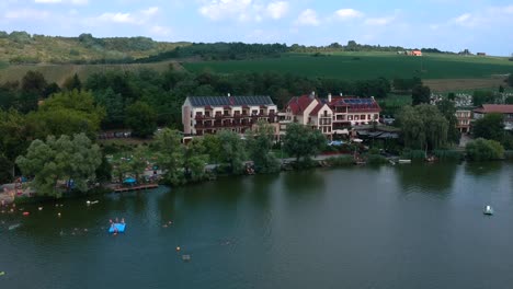 Aerial-footage-of-the-Lake-Wellness-Hotel-at-the-lakeshore-of-Bánk,-Nógrád-County,-Hungary