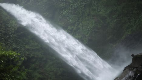 Tiro-Giratorio-En-Cámara-Lenta-Frente-A-Una-Cascada-De-Nungnung-En-Bali,-Indonesia,-Después-De-Una-Tormenta-De-Lluvia