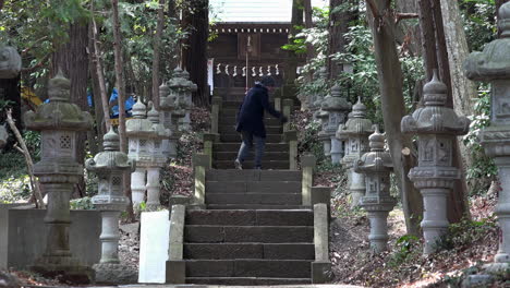 A-caucasian-guy-reaches-the-top-of-the-ladder-at-a-Japanese-traditional-temple-on-daytime