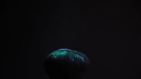 slow-motion-of-a-make-up-brush-with-blue-powder-explosion-and-burst-on-black-background