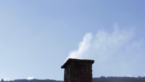 Close-up-shot-of-a-house-chimney-with-smoke-coming-out-of-it