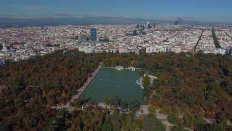 Drone-shot-of-the-Parque-de-El-Retiro-in-Madrid---drone-is-descending-facing-the-Great-Pond-and-the-city