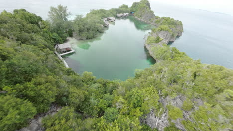 FPV-drone-dives-over-dream-destination-lagoon-in-Raja-Ampat,-Indonesia
