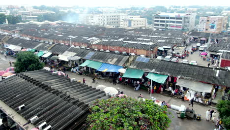 People-shopping-at-the-huge-Wuse-Market-in-Abuja,-Nigeria---aerial-descending-view