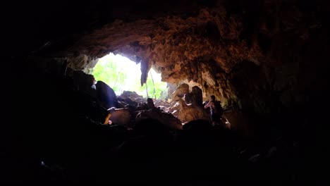 Höhle-Mit-Stalagmiten--Und-Stalaktitenbildung-Mit-Männern,-Die-Die-Höhle-Verlassen