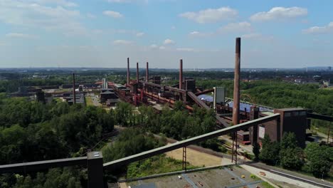 Drone-rising-up-near-Zollverein-coal-mine-coking-plant,-Essen,-Germany