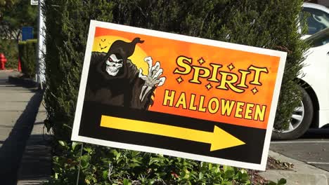 Spirit-Halloween-Store-Sign-with-Arrow-Stuck-in-Bushes