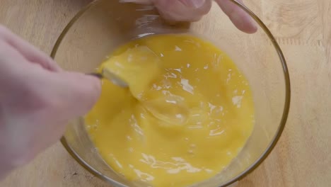 Slow-Motion-Shot-of-Whisking-Eggs-With-a-Fork-in-the-Kitchen