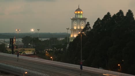 Johor-Bahru,-Torre-Del-Reloj-De-Malasia-Al-Atardecer,-Carretera-En-Primer-Plano