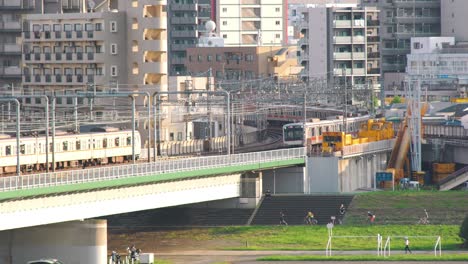 JR-Trains-Travelling-And-Crossing-On-The-Bridge-In-Tamagawaon-A-Sunny-Day-In-Tokyo,-Japan