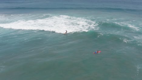 Surfeando-En-Las-Olas-Del-Océano-Pacífico,-Surfistas-Cerca-De-La-Costa-De-Acapulco,-México,-Vista-Aérea-Hacia-Atrás