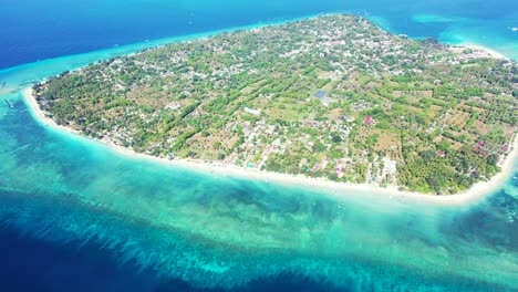 Gili-Air-island-with-clear-blue-water-and-white-sand-captured-from-the-air,-Indonesia