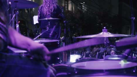 Camera-moving-in-slow-motion-pointed-at-drummer's-hands-playing-a-song-in-an-outdoor-concert