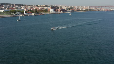 Paseo-En-Barco-Con-Un-Dron-Disparado-Con-El-Paisaje-Urbano-De-Lisboa-En-El-Fondo