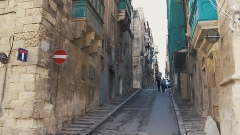 People-walking-in-narrow-street-in-Valleta,-Malta