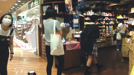 Japanese-Customers-Required-To-Sanitize-Their-Hands-Before-Entering-The-Shop-In-Kyoto,-Japan-During-Coronavirus-Pandemic---medium-shot