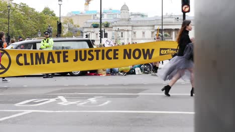 Sliding,-slow-motion-shot-reveals-yellow-climate-justice-now-sign-during-extinction-rebellion-protests-in-London