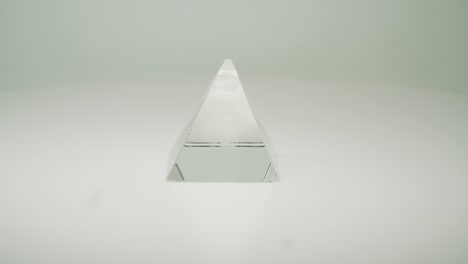 Una-Hermosa-Pirámide-De-Cristal-Transparente-Sobre-Fondo-Blanco-Puro---Primer-Plano