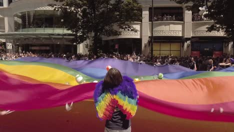 US-Bank-employees-participating-in-the-Seattle-LGBTQ-parade,-waving-a-giant-rainbow-flag