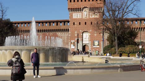 Hauptturm-Des-Sforzesco-Schloss-Auf-Der-Vorderen-Plaza-Mit-Menschen,-Die-An-Einem-Hellen,-Sonnigen-Tag-In-Mailand,-Italien,-Herumhängen-Und-Fotos-Machen