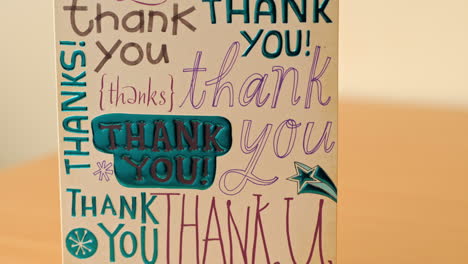 TILT-UP-Of-A-Cardboard-Thank-You-Card-Cover,-CLOSE-UP