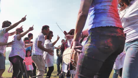 Colorful-people-at-Holi-Festival-dancing-around-drummer,-Low-angle,-Slow-motion