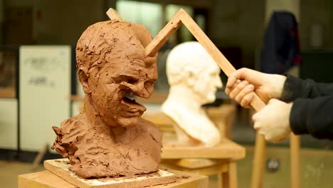 Clay-sculptor-destroying-his-own-work,-Destroying-a-clay-bust-with-a-stick-for-a-second-time