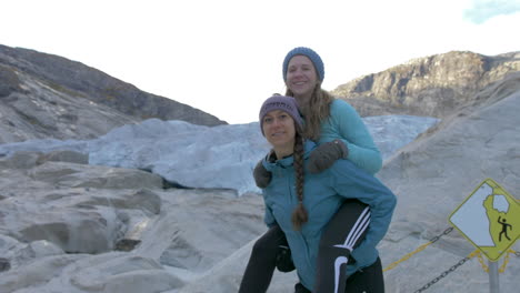 Two-Girls-Pose-for-a-Fun-Photo-by-a-Glacier-in-Norway