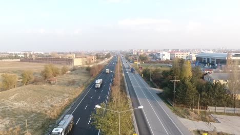 Highway-traffic-flow-at-city-entrance-drone-footage