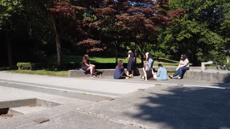 Pandemic-COVID-19-Lockdown-ignoring-disobediant-ladies-unmasked-share-lunch-in-close-range-less-than-6-feet-apart-or-2-meters-of-each-other-in-a-downtown-city-park-2-3