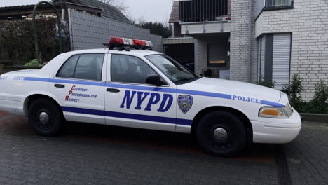 Mittlere-Aufnahme-Eines-Polizeiautos-Der-New-Yorker-Polizei,-Das-In-Der-Abenddämmerung-In-Der-Nachbarschaft-Parkt-Und-Wartet