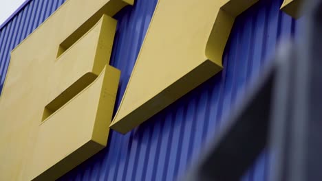 Close-Up-of-Yellow-Ikea-Logo-with-Big-Letters-on-Facade-in-Slow-Motion