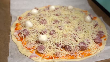Hand-placing-mozzarella-cheese-balls-on-homemade-pizza