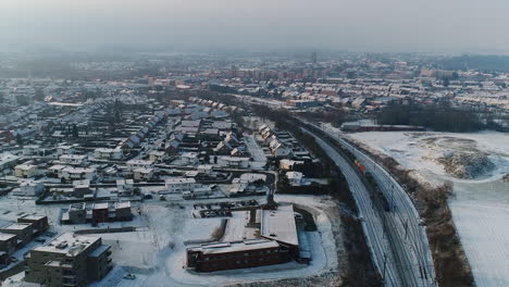 AERIAL:-A-city-and-its-residential-area's-on-a-snowy,-winter-day