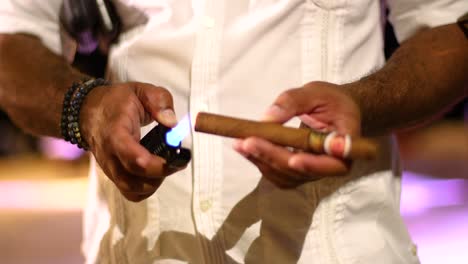 Close-up-of-Caribbean-male-holding-and-lighting-a-cigar-with-a-lighter