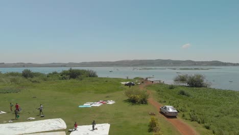 Aerial-of-Africans-by-the-shore-of-Lake-Victoria-washing-clothes-and-cars-in-rural-Africa